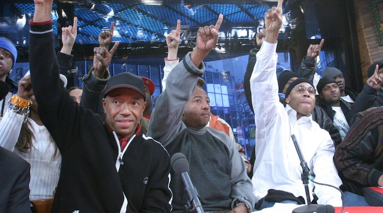 Hip-hop mogul Russell Simmons, left, Def Jam Records President Kevin Liles, center, and recording artist LL Cool J, foreground right, join others as they raise a single finger during the launch of the 'One Mind. One Vote.' campaign in New York, Monday, Jan. 19, 2004. Simmons endorsed Hillary Clinton for president Friday, saying she was a practical progressive he trusted while criticizing Sen. Bernie Sanders as “overstating what he can deliver to underserved communities.”