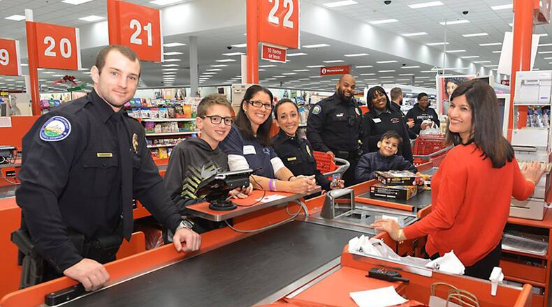 Roswell police officers shop with kids at a local Target store in 2017. The City Council has approved seeking a $2,000 grant from Target Corp. for this year’s “Heroes and Helpers” program, which pairs police officers with families and children to go shopping for holiday presents. ROSWELL POLICE DEPARTMENT via Facebook