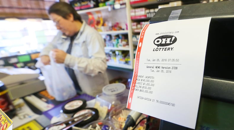 Marcia Eversole, manager of Dabbelts Market in Hamilton, Ohio, sells tickets for the Jan. 6 Powerball drawing, which no one won. GREG LYNCH / STAFF