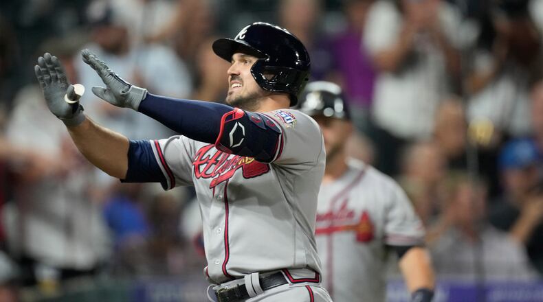 The Braves' Adam Duvall celebrates as he crosses home plate after hitting a two-run home run off Colorado Rockies relief pitcher Yency Almonte in the fifth inning Thursday night in Denver. (AP Photo/David Zalubowski)
