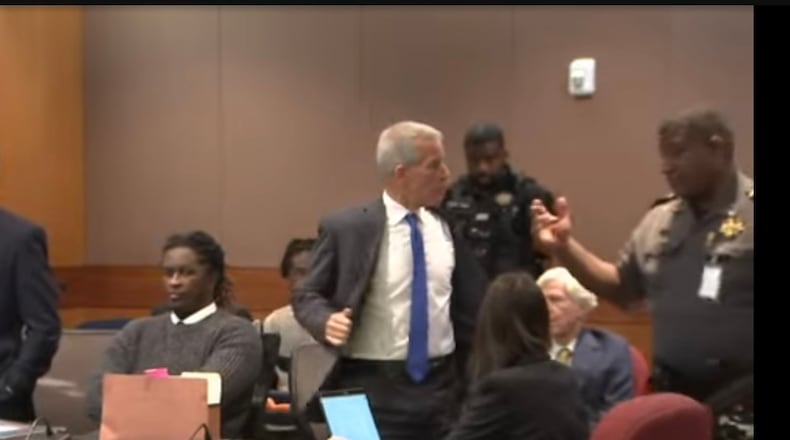 Brian Steel, attorney for rapper Young Thug, removes his suit jacket and tie before heading to a short stint in lockup after being found in contempt of court.