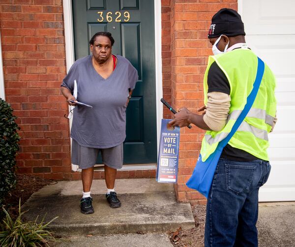 Jenjins Kologbo talks to Angela Alford while canvassing in a Scottdale neighborhood in December 2020  STEVE SCHAEFER FOR THE ATLANTA JOURNAL-CONSTITUTION