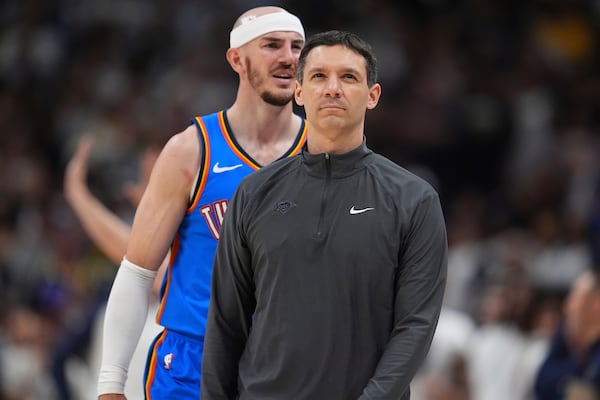 Oklahoma City Thunder head coach Mark Daigneault, front, heads to confer with assistant coaches during a time out as guard Alex Caruso argues with a referee after being called for a foul in the second half of Game 6 in the Western Conference semifinals of the NBA basketball playoffs against the Denver Nuggets Thursday, May 15, 2025, in Denver. (AP Photo/David Zalubowski)