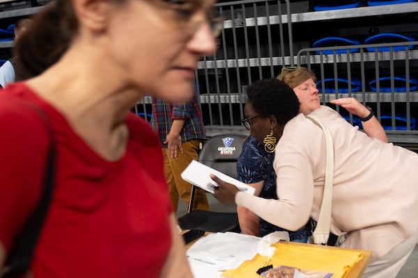 NPU-V Chair Caitlin Barringer (in blue) gets a hug from Cala Morrison after a contentious, three-hour meeting April 13, 2026. (Ben Gray for the AJC)