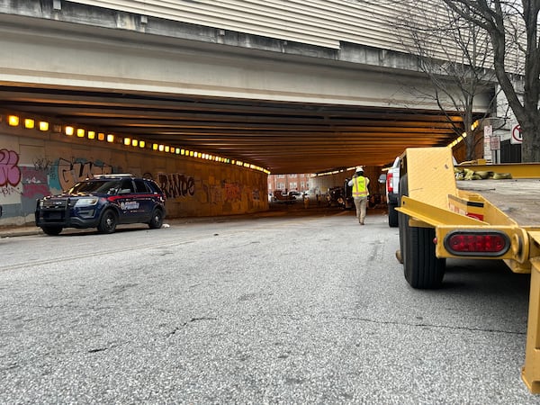 By Saturday morning, the encampment under I-85 near Grady Memorial Hospital was no longer standing. The last concrete barriers were being removed and piles of trash were being loaded into trucks. (Caroline Silva/AJC)