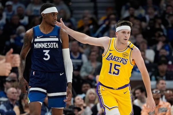 Los Angeles Lakers guard Austin Reaves (15) gestures next to Minnesota Timberwolves forward Jaden McDaniels (3) after making a 3-point basket during the first half of Game 3 of an NBA basketball first-round playoff series, Friday, April 25, 2025, in Minneapolis. (AP Photo/Abbie Parr)