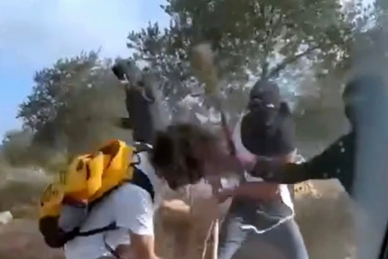 This Oct. 19, 2025, image taken from video shows what appear to be masked settlers beating activists and Palestinian farmers in Turmus Ayya, West Bank. (AP Photo)