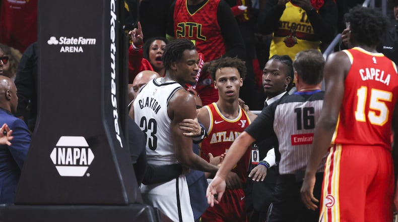 Hawks guard Dyson Daniels glares at Nets center Nic Claxton (33) as they both return to the court after going into the stands after an altercation during the second half at State Farm Arena, Wednesday, October 23, 2024, in Atlanta. (Jason Getz / AJC)
