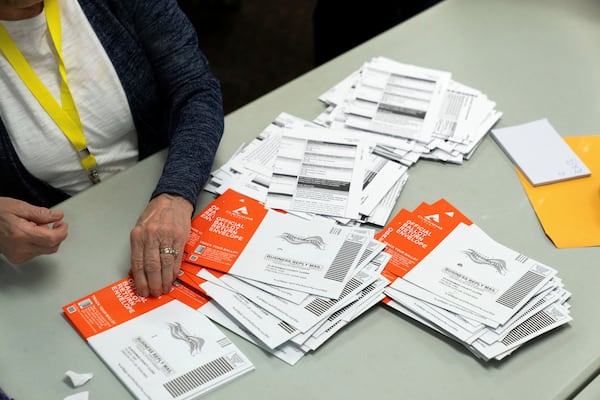 An election worker reaches for an unopened ballot during sorting in Oregon in 2024. (Jenny Kane/AP)