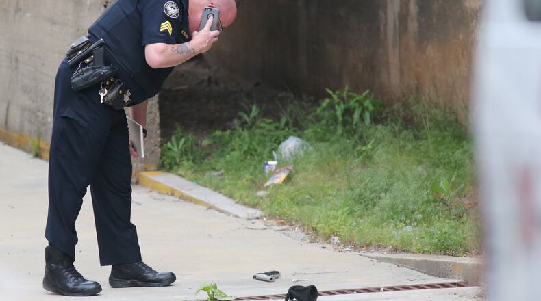 An Atlanta police officer checks on a gun found near the Martin Luther King Jr. Federal Building in downtown Atlanta. JOHN SPINK / JSPINK@AJC.COM