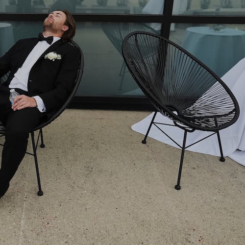 FILE - A Groomsman takes a break after finishing bridal party photos at a wedding on Saturday, Aug. 23, 2025, in Newtown, Ohio. (AP Photo/Joshua A. Bickel, File)