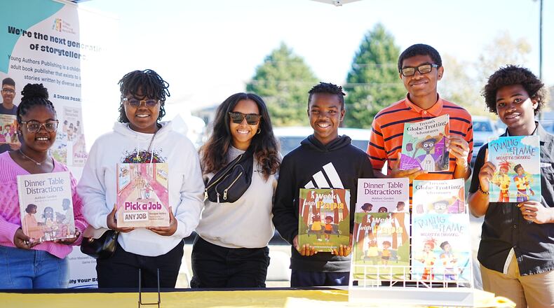 Leah Hernandez poses with young authors and their books. She created Young Authors Publishing to share narratives written by diverse authors. "Working with kid authors has been more fun than working with adult authors only because I feel like kids really know what they want," she says. (Courtesy of Leah Hernandez)