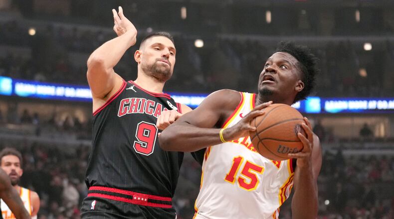Atlanta Hawks' Clint Capela (15) eyes the basket as Chicago Bulls' Nikola Vucevic defends during the first half of an NBA basketball game Friday, Nov. 22, 2024, in Chicago. (AP Photo/Charles Rex Arbogast)