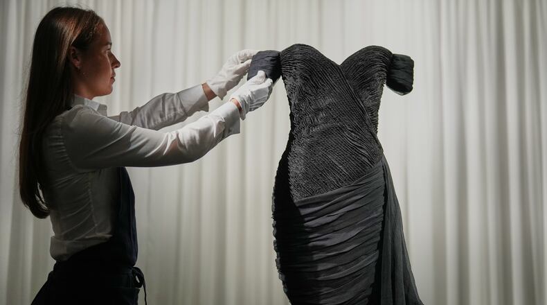 A dress worn by the late Princess Diana and known as the ''Revenge Dress'', designed by Christina Stambolian, is unveiled by staff at Sotheby’s auction house in London, Friday, Sept. 18, 2026, ahead of its Dec. 9 auction in New York, where it is estimated to sell for US$150,000-300,000. (AP Photo/Alastair Grant)