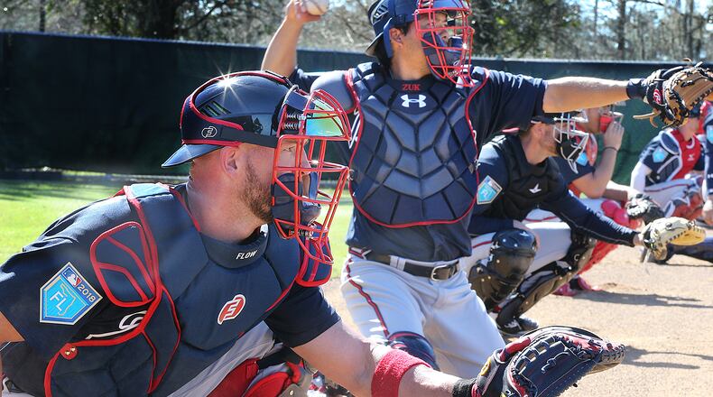 Braves catchers Tyler Flowers (left) and Kurt Suzuki work with pitchers in the bullpen Saturday, Feb 17, 2018, at the ESPN Wide World of Sports Complex in Lake Buena Vista, Fla. (Curtis Compton/ccompton@ajc.com)