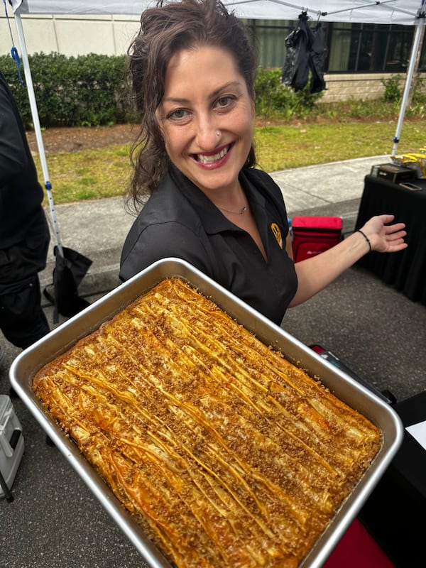 Two Birds Greek Street Food chef Elena Mouzakitis-Hugley, who co-owns the business with her husband Sonny Hugley, holds a pan of her baklava custard, a hybrid of the Greek desserts galactoboureko (Greek custard baked in phyllo) and baklava. (Courtesy of Two Birds Greek Street Food)