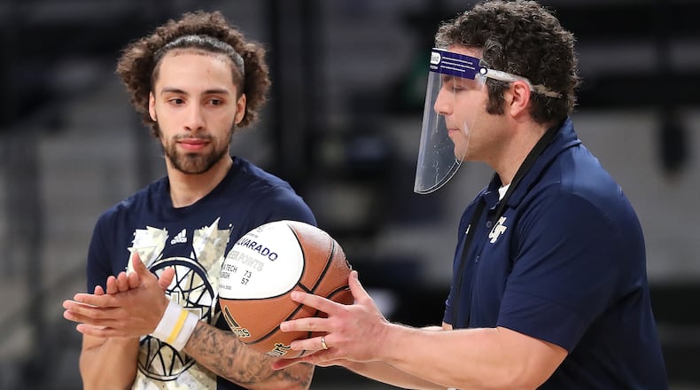Georgia Tech head coach Josh Pastner presents guard Jose Alvarado a basketball recognizing him as a member of the 1,000 point club in a pregame ceremony before playing Clemson Tuesday, Jan. 20, 2021, in Atlanta.