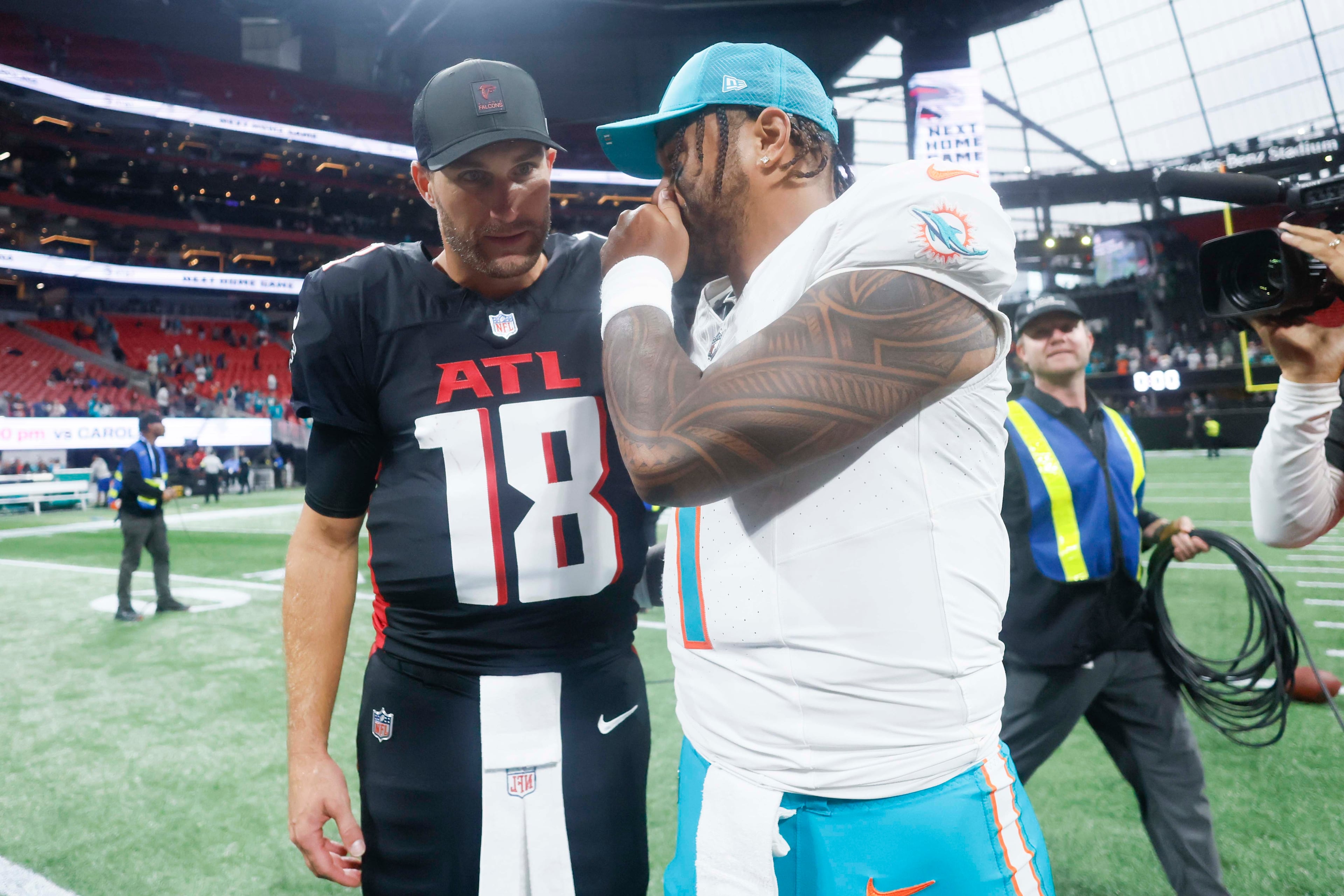 Miami Dolphins quarterback Tua Tagovailoa (right) speaks with Atlanta Falcons quarterback Kirk Cousins (left) after the game at Mercedes-Benz Stadium in Atlanta on Sunday, Oct. 26, 2025. The Miami Dolphins defeated the Atlanta Falcons 34-10.(Miguel Martinez/AJC)
