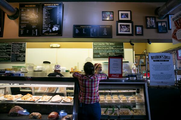 Gabriella Hartz gets a sandwich to go before the lunch rush hour at Reuben’s Deli in downtown. Owner Claudio Furgiuele says, “Foot traffic here has not come back. But the attitude downtown now is positive and it feels good to be downtown again.” (Rebecca Wright for the Atlanta Journal-Constitution)