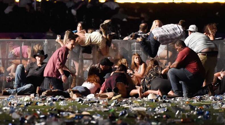 People scramble for shelter after a gunman opened fire at a music festival in Las Vegas. Wire photo.