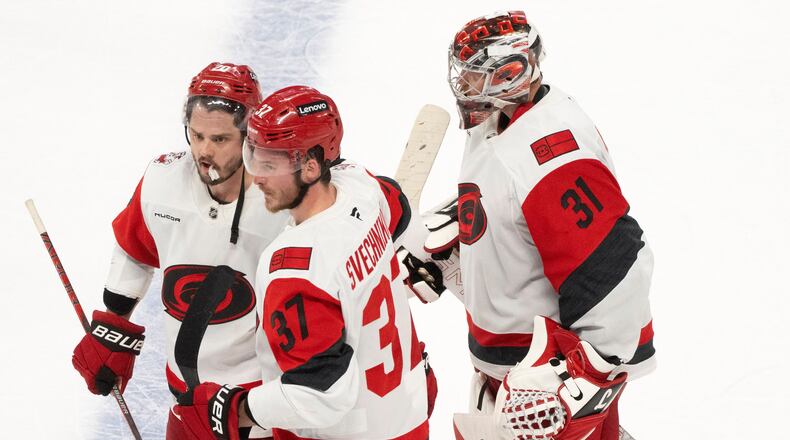 Carolina Hurricanes' Sebastian Aho (20) and Andrei Svechnikov (37) celebrate in front of Hurricanes goaltender Frederik Andersen (31) after the winning goal by Aho in overtime of Game 3 of the Eastern Conference finals NHL hockey Stanley Cup playoff series against the Montreal Canadiens in Montreal, Monday, May 25, 2026. (Christinne Muschi/The Canadian Press via AP)