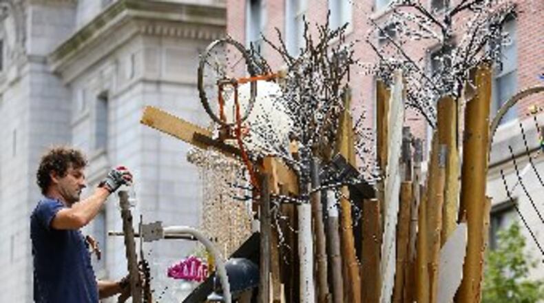 Savannah artist Marcus Kenney transforms a dumpster into a visual arts environment called “Timeline” using objects of previous existence on Forsyth Street downtown. The “Dumpsters” project, involving more than 20 artists that have been given 10 metal trash receptacles to create a work of public art, will be part of this year’s “Elevate.” The Office of Cultural Affairs’ free weeklong public art event runs Oct. 17-23. CURTIS COMPTON / CCOMPTON@AJC.COM
