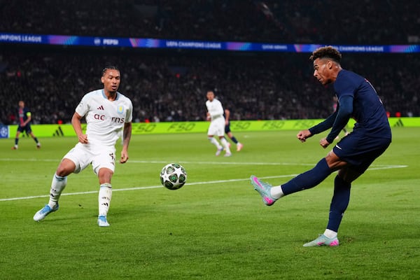 PSG's Desire Doue, right, takes a shot during the Champions League quarterfinal first leg soccer match between Paris Saint-Germain and Aston Villa at Parc des Princes stadium in Paris, Wednesday, April 9, 2025. (AP Photo/Aurelien Morissard)