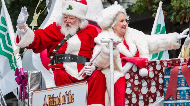 Mr. and Mrs. Santa Claus wave to the crowd during the Children's Christmas Parade Saturday, December 03, 2016, in Atlanta.