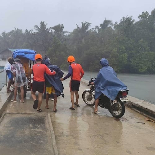 In this photo provided by the Philippine Coast Guard, rescuers evacuate people to safer grounds in Quezon province, eastern Philippines as Typhoon Fung-wong enters the country on Sunday Nov. 9 2025. (Philippine Coast Guard via AP)
