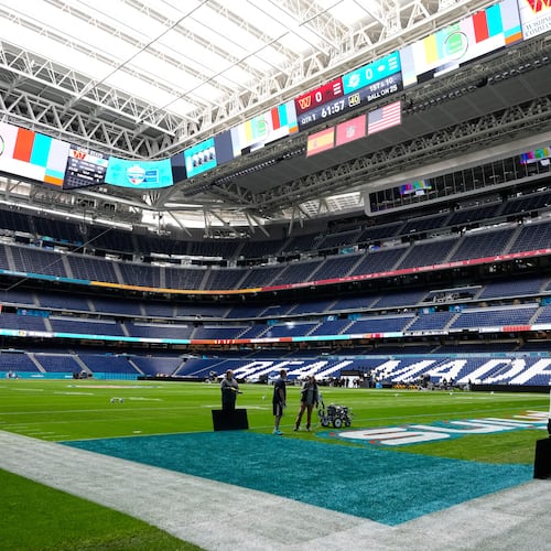 Workers prepare the field at the Santiago Bernabeu stadium ahead of an NFL game between the Miami Dolphins and Washington Commanders in Madrid, Spain, Friday, Nov. 14, 2025. (AP Photo/Steve Luciano)