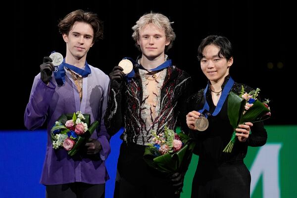 From left, silver medalist Mikhail Shaidorov, of Kazakhstan; gold medalist Ilia Malinin, of the United States; and bronze medalist Yuma Kagiyama, of Japan, pose for photos during a medal ceremony for men's free skating at the figure skating world championships, Saturday, March 29, 2025, in Boston. (AP Photo/Charles Krupa)