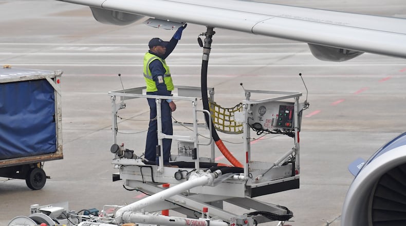 A member of a Delta ground crew prepares a jet for departure at Hartsfield-Jackson International Airport in this February file photo. HYOSUB SHIN / HSHIN@AJC.COM