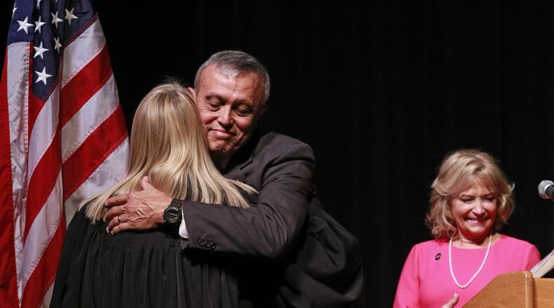 Mike Boyce hugs Cobb State Court Judge Marsha Lake after he was sworn in. At right is his wife, Judy. In a ceremony at the Cobb Civic Center, Mike Boyce was sworn in Friday as Cobb County’s next chair. BOB ANDRES /BANDRES@AJC.COM