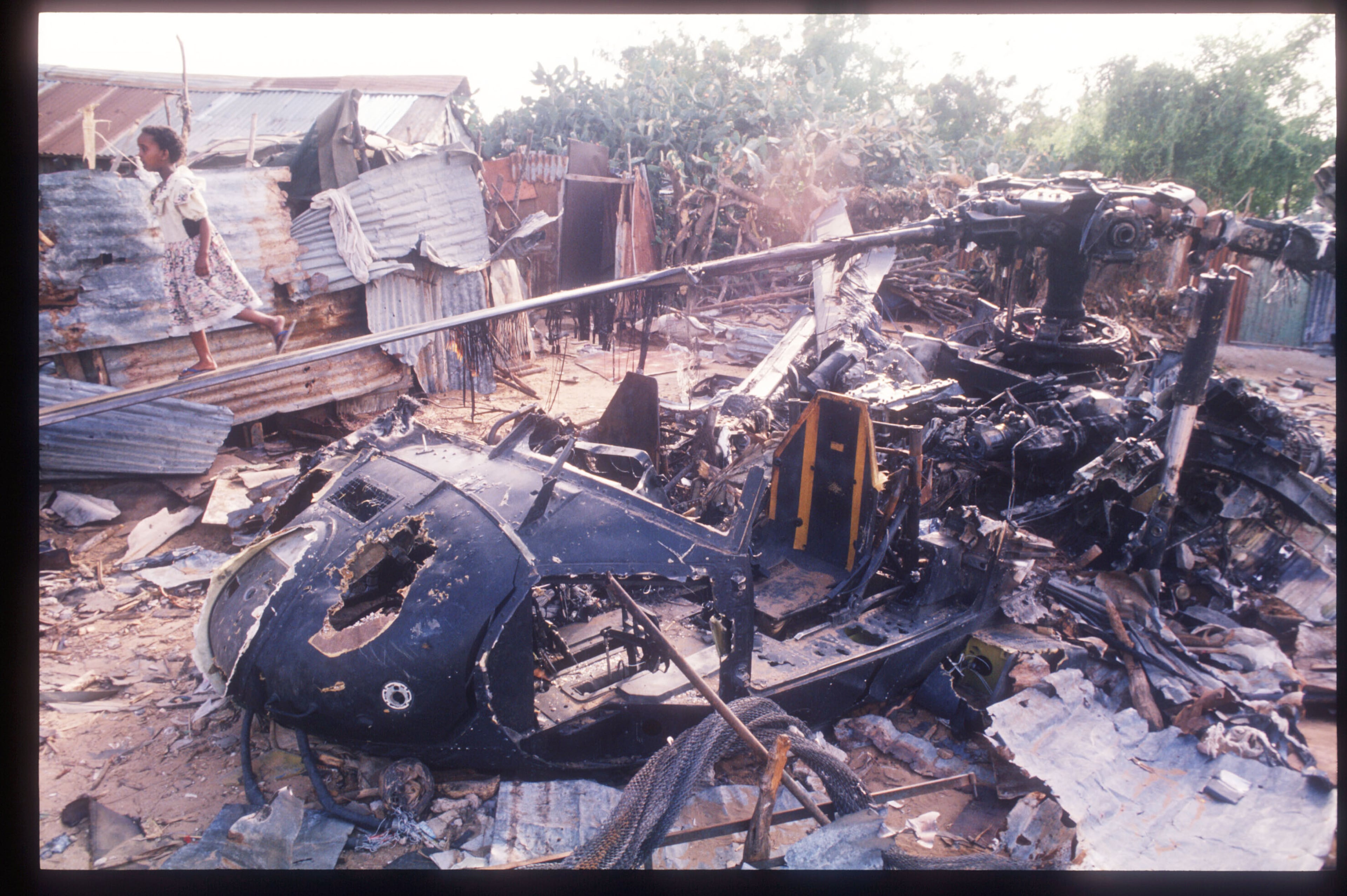 Children walk along the rotor of a wrecked American helicopter in Mogadishu, Somalia. This Blackhawk helicopter, which was used to root out ammo caches, was subsequently shot down by Somali warlords. (Scott Peterson/Liaison 1993)