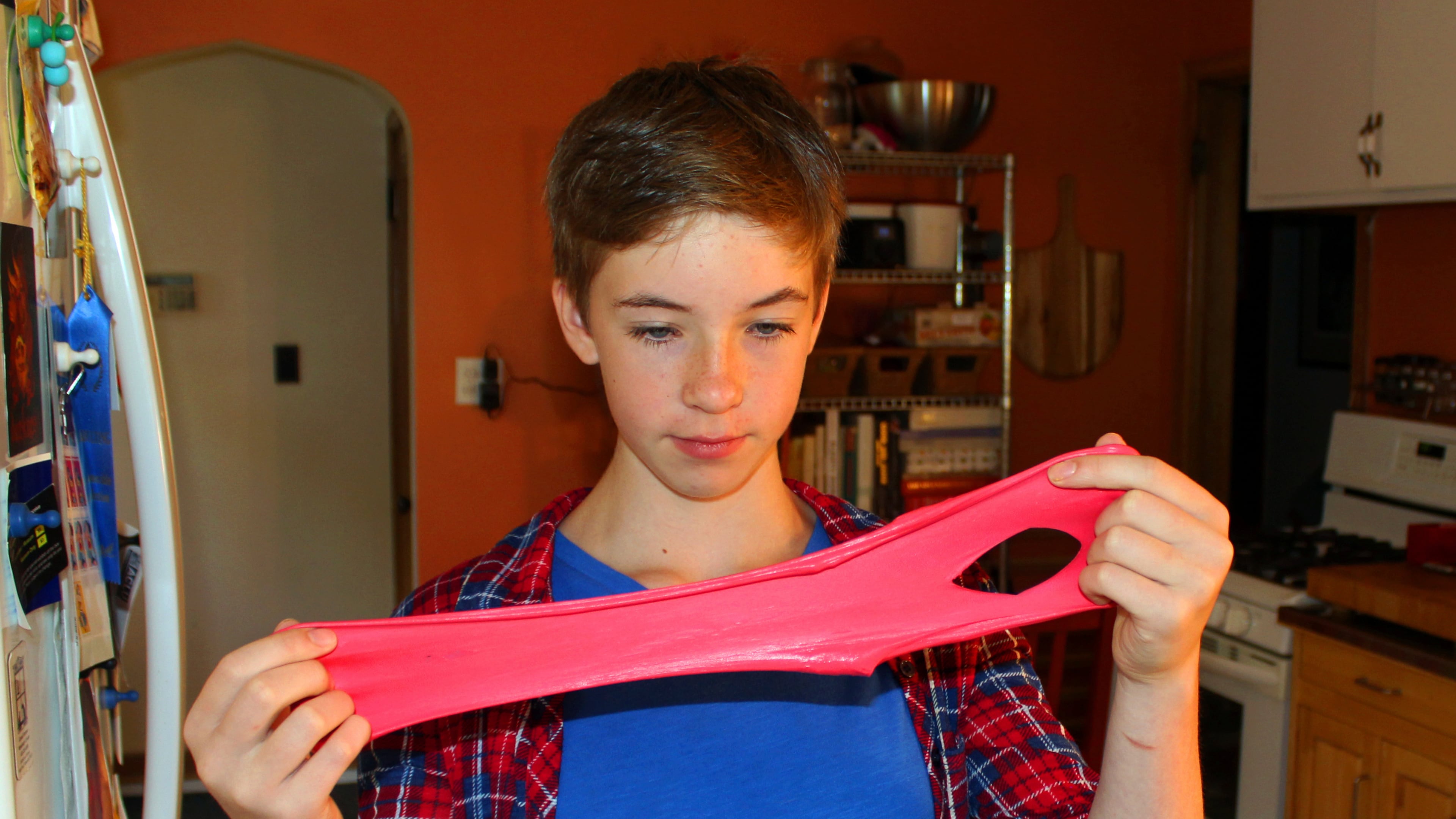 FILE - Astrid Rubens demonstrates the elasticity of homemade slime in her kitchen in St. Paul, Minn., June 21, 2017. (AP Photos/Jeff Baenen, File)