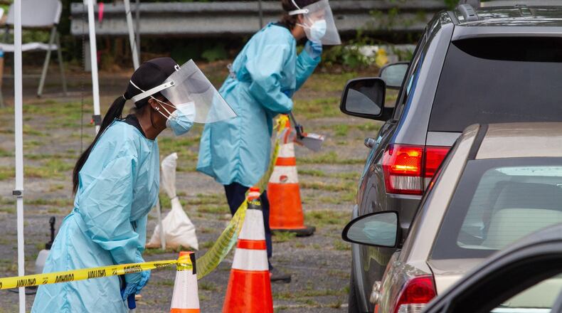 CORE employees take samples and information from protesters as they drive through the free COVID-19 testing site at the Chosewood Arts Complex Saturday, June 6, 2020. STEVE SCHAEFER FOR THE AJC