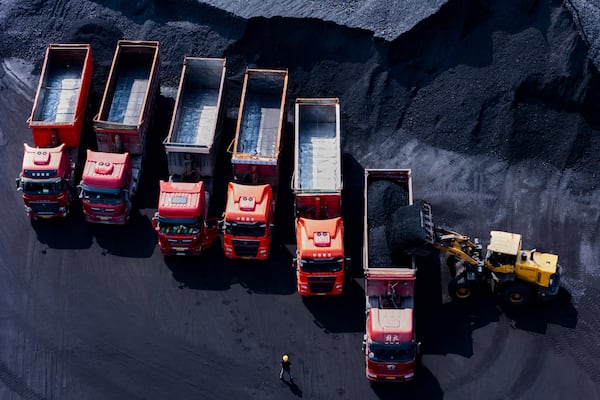 Workers load coal on trucks at a coal yard port on the Yangtze River in southwest China's Chongqing Municipality on Sunday, April 20, 2025. (Chinatopix Via AP)