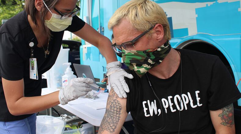 John Letson gets his first dose of the Pfizer-BioNTech vaccine at a Denver Public Health mobile vaccine clinic behind a bus stop in Aurora, Colorado, on June 23, 2021. Letson was nervous about getting inoculated until he spoke to his doctor, who dispelled some of the vaccine myths he had heard. (Markian Hawryluk/KHN/TNS)