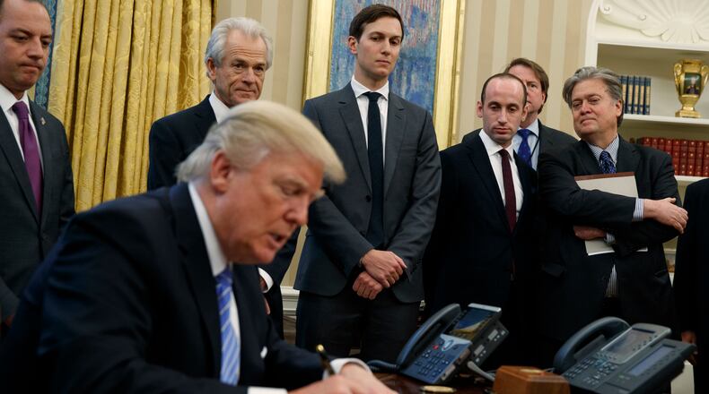 From left, White House Chief of Staff Reince Priebus, National Trade Council adviser Peter Navarro, Senior Adviser Jared Kushner, policy adviser Stephen Miller, and chief strategist Steve Bannon watch as President Donald Trump signs an executive order in the Oval Office of the White House, Monday, Jan. 23, 2017, in Washington. (AP Photo/Evan Vucci)