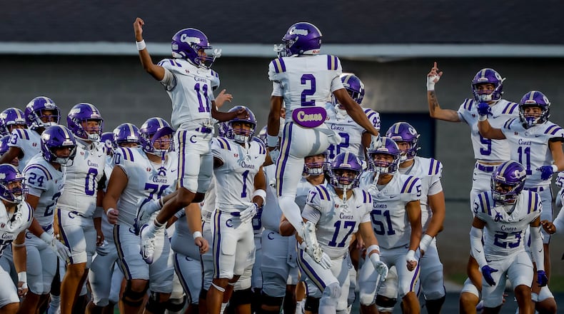 Cartersville’s Lance Tippett (left) and Grayson Warmack lead their teammates onto the field before their game against Hiram on Friday, Aug. 21, 2026, in Hiram. (Erik S. Lesser for the AJC)