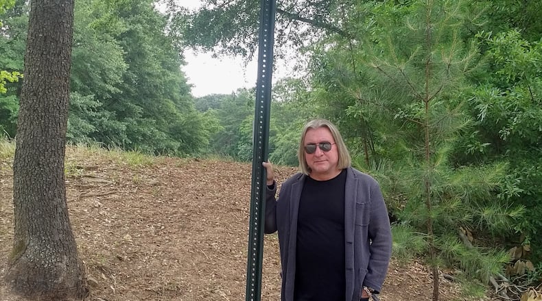 Peter Conlon with the new sign honoring Alex Cooley near Chastain Park Amphitheatre. Photo: Melissa Ruggieri/AJC