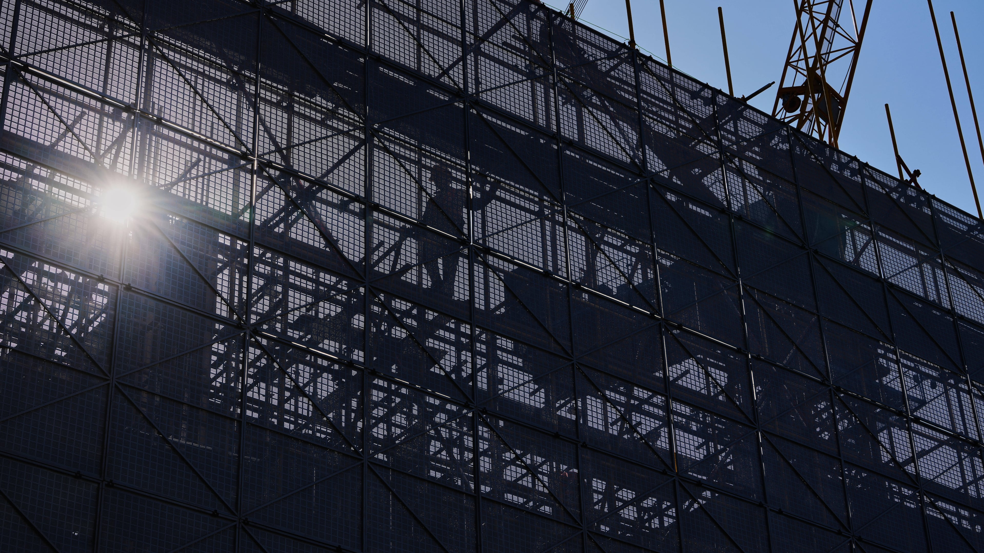 A worker installs scaffolding at a building under construction at the capital popular shopping district, in Beijing, Tuesday, Oct. 21, 2025. (AP Photo/Andy Wong)