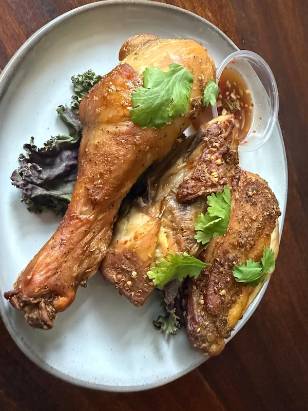 The kai yang at Gu Thai sports a crispy, mahogany skin while remaining incredibly juicy and flavorful on the inside. (Angela Hansberger for the AJC)