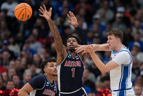 Duke forward Cooper Flagg (2) passes against Arizona guard Caleb Love (1) during the first half of a Sweet 16 round NCAA college basketball tournament game, Thursday, March 27, 2025, in Newark, N.J. (AP Photo/Frank Franklin II)