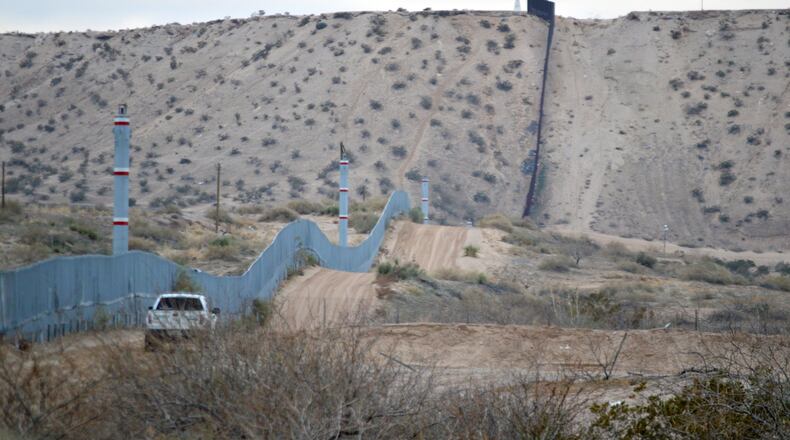 FILE - In this Jan. 4, 2016 photo, a U.S. Border Patrol agent drives near the U.S.-Mexico border fence in Sunland Park, N.M. Can Donald Trump really make good on his promise to build a wall along the 2,000-mile U.S.-Mexican border to prevent illegal migration? What’s more, can he make Mexico pay for it? Sure, he can build it, but it’s not nearly as simple as he says. (AP Photo/Russell Contreras)
