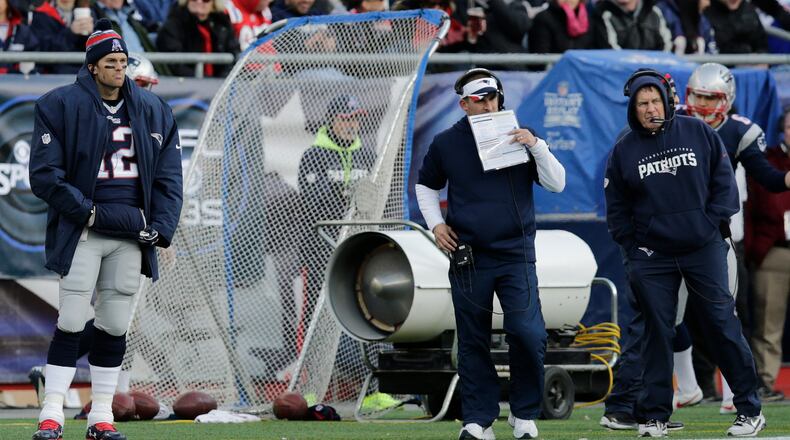 New England Patriots quarterback Tom Brady (12) on the sidelines with offensive coordinator Josh McDaniels, center, and head coach Bill Belichick in the second half of an NFL football game against the Buffalo Bills, Sunday, Dec. 28, 2014, in Foxborough, Mass. (AP Photo/Charles Krupa) Should Josh McDaniels (center, between Tom Brady and Bill Belichick) be considered favorite for Falcons' job? (AP)