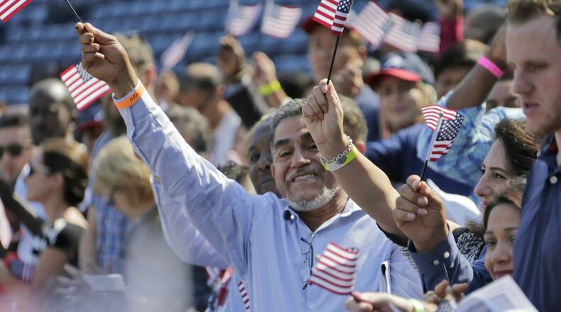 Newly sworn in citizens cheer and wave flags after taking their oath of citizenship. An official with ProGeorgia, a nonprofit organization that helps register voters, said “approximately 426” people who attempted to register at Georgia naturalization ceremonies have been flagged as potential noncitizens and placed into pending status. A federal judge considered their case Monday and said she will deliver a decision in time for next week’s election. BOB ANDRES /BANDRES@AJC.COM