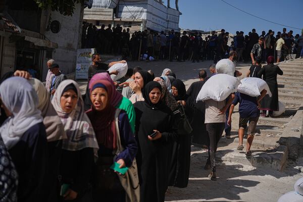 Palestinians line up to receive bags of flour distributed by the World Food Programme (WFP) in Gaza City, northern Gaza Strip, on Thursday, June 26, 2025. (AP Photo/Jehad Alshrafi)