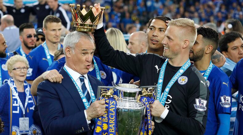 FILE - Leicester City team manager Claudio Ranieri has the crown of the trophy placed on his head by Leicester goalkeeper Kasper Schmeichel as they celebrate becoming the English Premier League soccer champions at King Power stadium in Leicester, England, May 7, 2016. (AP Photo/Matt Dunham, File)