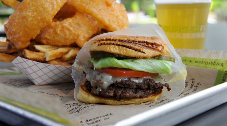 BurgerFi's Brisket Burger: a double-natural, 28-day dry-aged ground brisket, Swiss cheese, blue cheese, lettuce, tomato, pickles and BurgerFi sauce. Served with Cry & Fries (onion rings with fresh cut fries) and a draft beer.